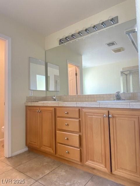 8374 Pioneer Way, Las Vegas, NV 89113 - bathroom with tile patterned floors, double vanity, and toilet