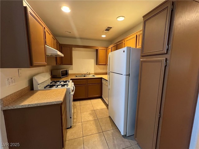 kitchen featuring recessed lighting, white appliances, light tile patterned floors, under cabinet range hood, and visible vents