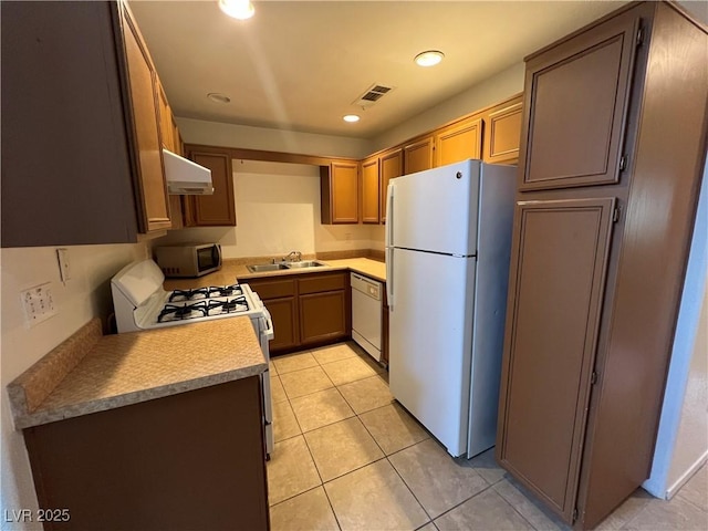 kitchen with white appliances, light tile patterned floors, exhaust hood, visible vents, and a sink