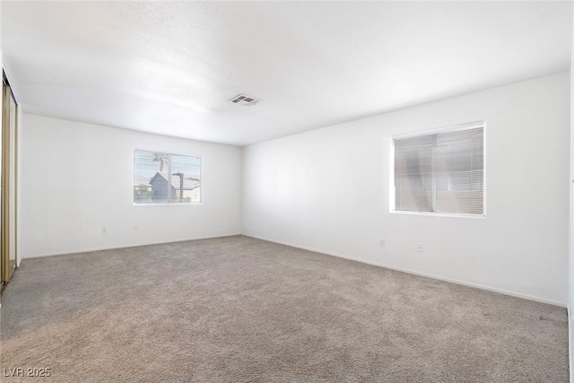 spare room featuring visible vents and carpet flooring