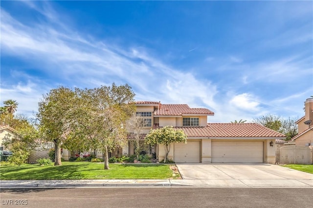 mediterranean / spanish house with a tiled roof, stucco siding, a front yard, an attached garage, and concrete driveway