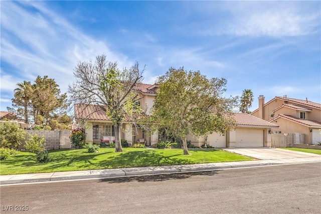 view of property hidden behind natural elements with stucco siding, an attached garage, a front yard, a tile roof, and fence