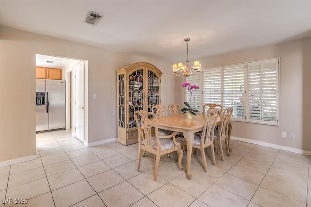dining area featuring a chandelier, light tile patterned floors, visible vents, and baseboards