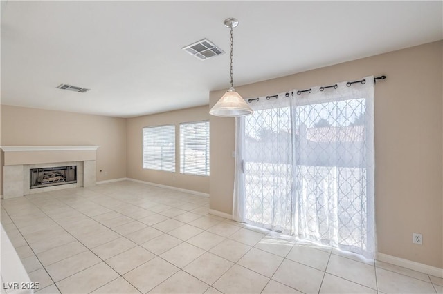 unfurnished living room featuring a fireplace, visible vents, baseboards, and light tile patterned flooring