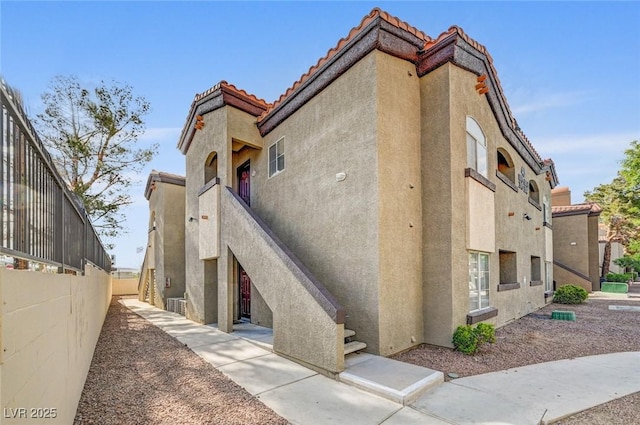 9000 Las Vegas Blvd Unit 1047, Las Vegas, NV 89123 - view of property exterior featuring a tile roof, stairs, stucco siding, and fence