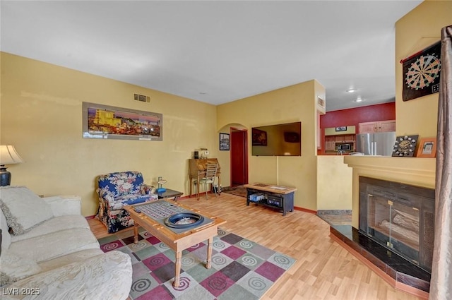 9000 Las Vegas Blvd Unit 1047, Las Vegas, NV 89123 - living room with visible vents, baseboards, arched walkways, wood finished floors, and a tiled fireplace
