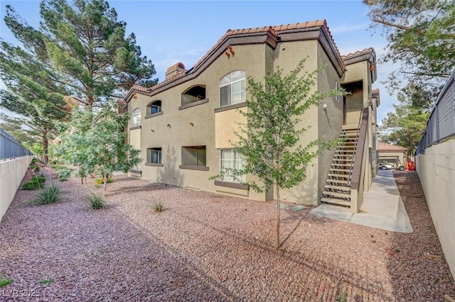 9000 Las Vegas Blvd Unit 1047, Las Vegas, NV 89123 - rear view of property with a tile roof, stairway, stucco siding, and fence