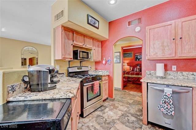 9000 Las Vegas Blvd Unit 1047, Las Vegas, NV 89123 - kitchen featuring light stone counters, arched walkways, visible vents, and appliances with stainless steel finishes