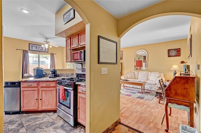 9000 Las Vegas Blvd Unit 1047, Las Vegas, NV 89123 - kitchen with arched walkways, light stone counters, appliances with stainless steel finishes, a ceiling fan, and open floor plan