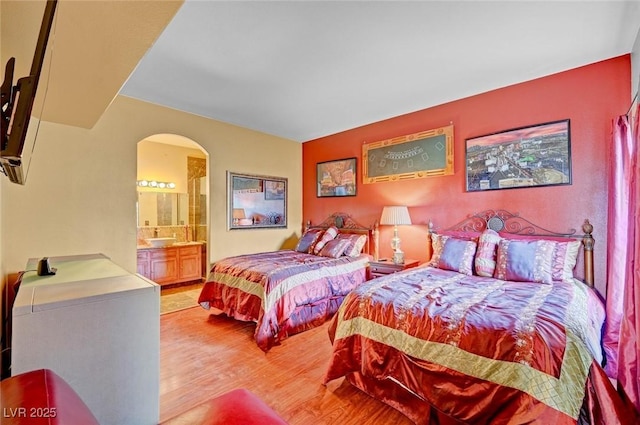 9000 Las Vegas Blvd Unit 1047, Las Vegas, NV 89123 - bedroom featuring arched walkways, light wood-style flooring, and connected bathroom