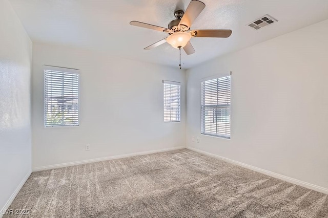 spare room featuring ceiling fan, baseboards, carpet, and visible vents
