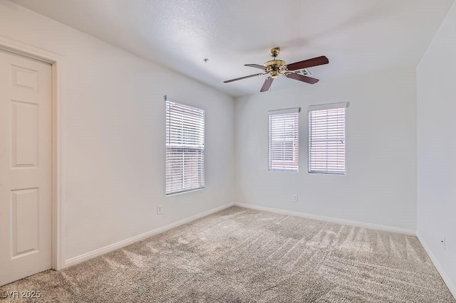 empty room with baseboards, light colored carpet, and a ceiling fan
