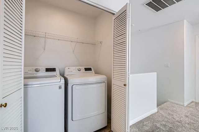laundry room featuring washing machine and dryer, carpet, visible vents, and laundry area