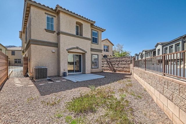 rear view of property with cooling unit, a fenced backyard, and stucco siding