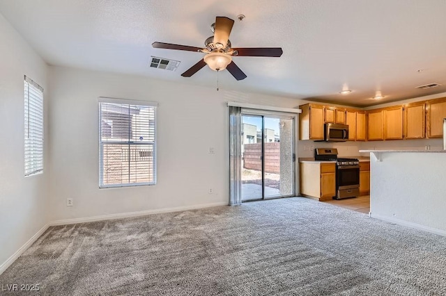 interior space with light carpet, light countertops, visible vents, ceiling fan, and appliances with stainless steel finishes