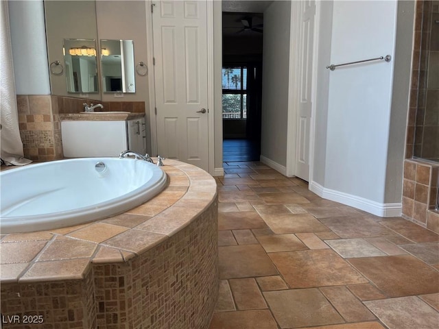 8209 Chapelle Ct, Las Vegas, NV 89131 - full bathroom featuring a garden tub, stone tile flooring, baseboards, vanity, and ceiling fan