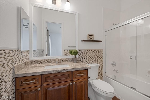 8209 Chapelle Ct, Las Vegas, NV 89131 - bathroom featuring tile walls, vanity, wainscoting, toilet, and enclosed tub / shower combo