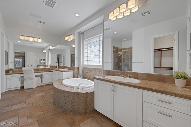 8209 Chapelle Ct, Las Vegas, NV 89131 - full bathroom featuring a shower stall, two vanities, a bath, and stone tile flooring