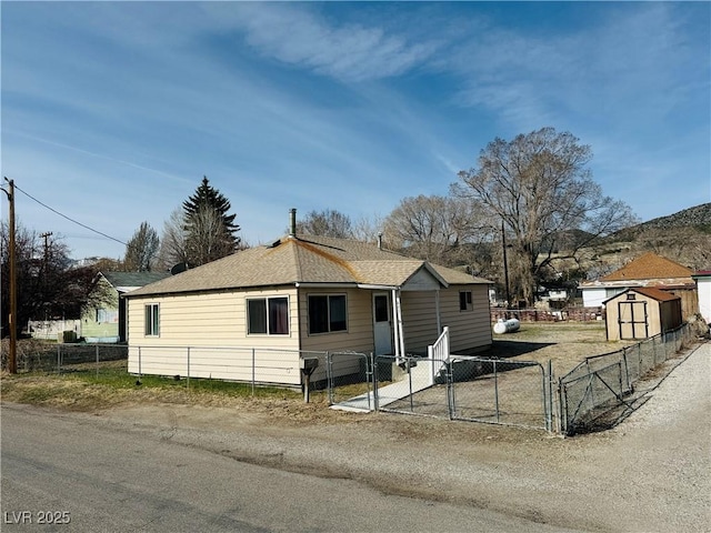 view of front of home featuring a shed, fence private yard, an outdoor structure, and a gate
