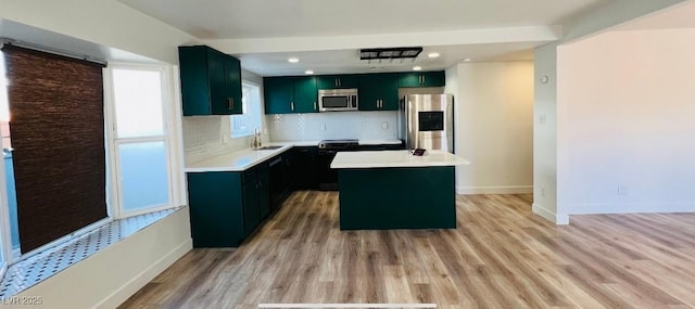 1801 Griffith Ave, Las Vegas, NV 89104 - kitchen featuring stainless steel appliances, light countertops, light wood-style flooring, decorative backsplash, and a kitchen island