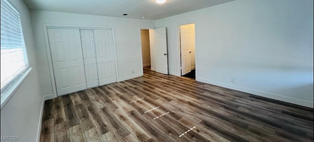 1801 Griffith Ave, Las Vegas, NV 89104 - unfurnished bedroom with a closet, dark wood-style flooring, and multiple windows