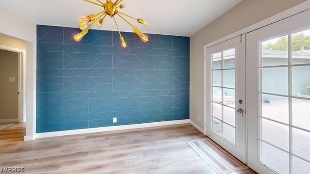 1801 Griffith Ave, Las Vegas, NV 89104 - unfurnished dining area featuring french doors, wood finished floors, and an accent wall