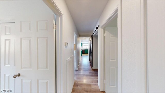 1801 Griffith Ave, Las Vegas, NV 89104 - hallway featuring light wood-style flooring and a barn door