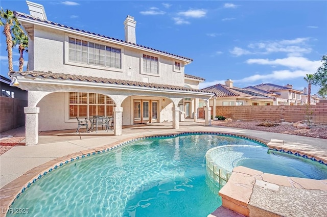 3755 Broadmead St, Las Vegas, NV 89147 - back of property with a chimney, a fenced backyard, stucco siding, a pool with connected hot tub, and a patio area