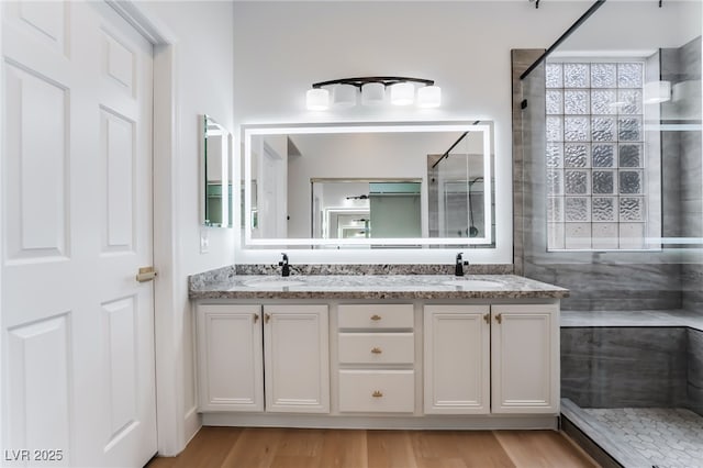 3057 Sunrise Heights Dr, Henderson, NV 89052 - bathroom with a sink, a tile shower, double vanity, and wood finished floors
