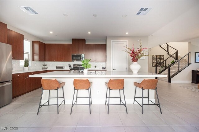 kitchen with visible vents, appliances with stainless steel finishes, and a breakfast bar area
