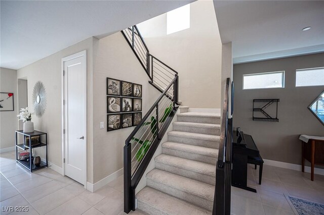 staircase featuring tile patterned floors and baseboards