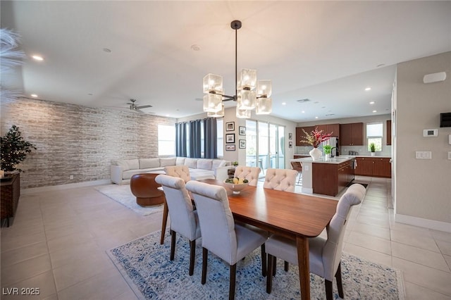dining area with light tile patterned floors, baseboards, brick wall, recessed lighting, and ceiling fan with notable chandelier