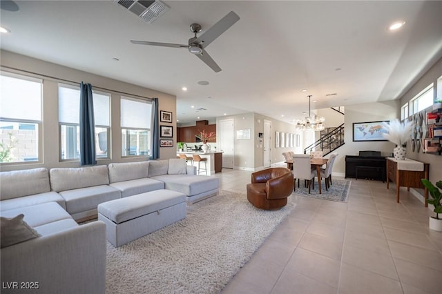 living area with visible vents, baseboards, recessed lighting, ceiling fan with notable chandelier, and light tile patterned flooring