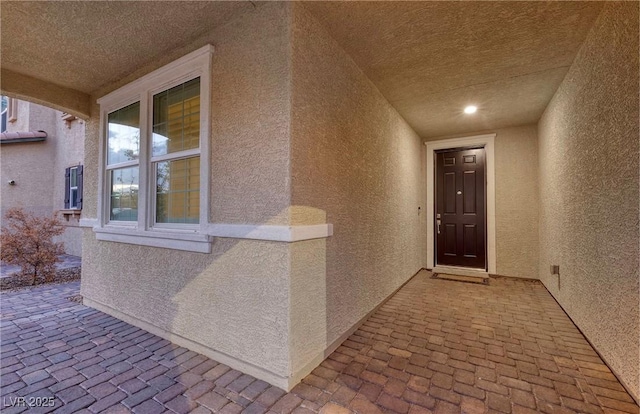 property entrance with a patio and stucco siding