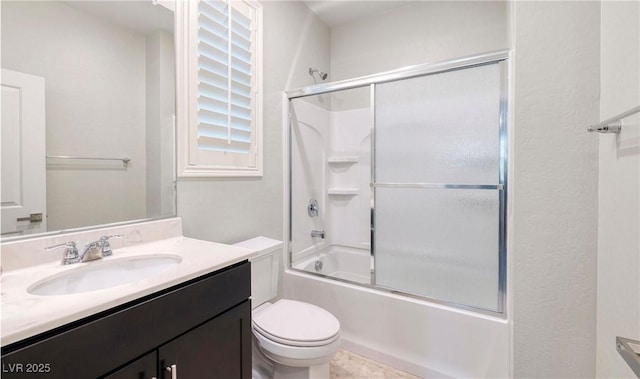 full bathroom with combined bath / shower with glass door, vanity, and toilet