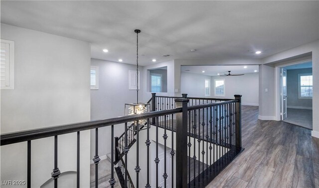 corridor with visible vents, recessed lighting, wood finished floors, an upstairs landing, and baseboards