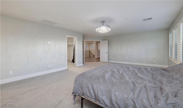 bedroom featuring light carpet, baseboards, a spacious closet, and visible vents
