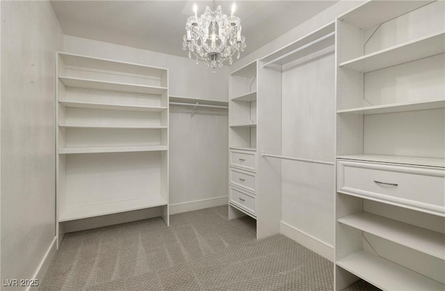 spacious closet with an inviting chandelier and carpet flooring