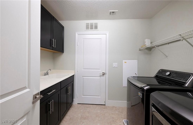 clothes washing area with independent washer and dryer, visible vents, a sink, and cabinet space