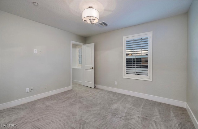 empty room with visible vents, baseboards, and carpet