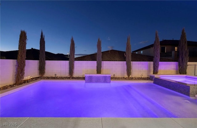 view of pool featuring a fenced backyard and a pool with connected hot tub