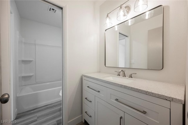 full bathroom with washtub / shower combination, vanity, visible vents, and wood finished floors
