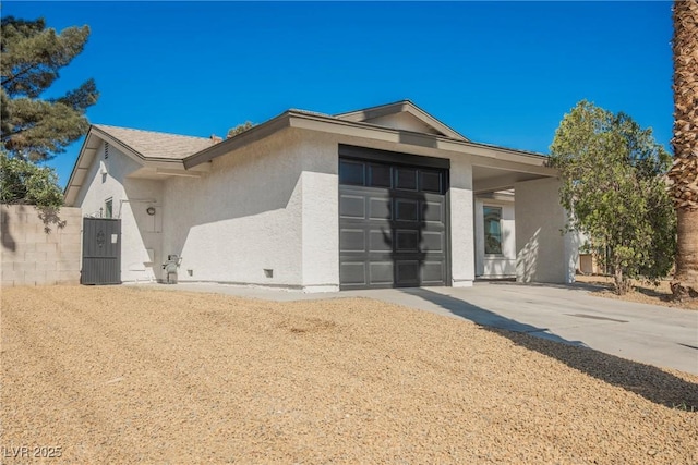 view of front of home featuring stucco siding, driveway, and a garage