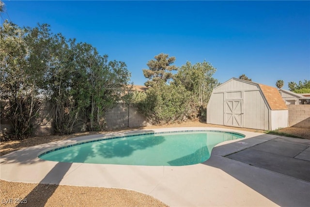 view of pool featuring a patio, a shed, an outbuilding, a fenced backyard, and a fenced in pool