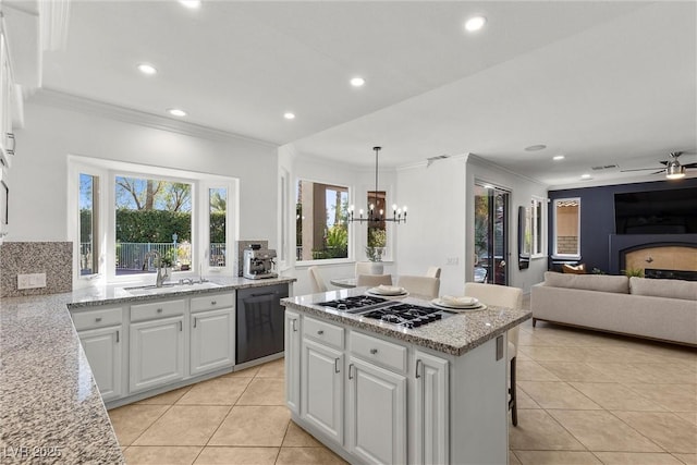 kitchen with a sink, black dishwasher, ornamental molding, stainless steel gas stovetop, and light tile patterned flooring
