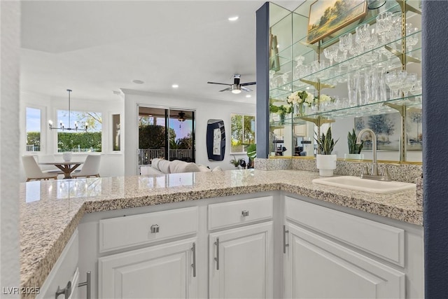 interior space featuring recessed lighting, vanity, ornamental molding, and ceiling fan with notable chandelier