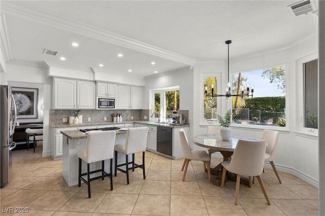 kitchen featuring visible vents, a center island, appliances with stainless steel finishes, and decorative backsplash
