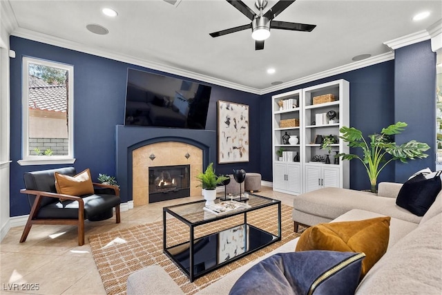 tiled living area with ceiling fan, crown molding, a tiled fireplace, and recessed lighting