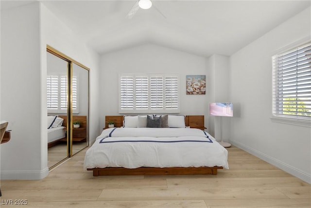 bedroom featuring a closet, vaulted ceiling, wood finished floors, and baseboards
