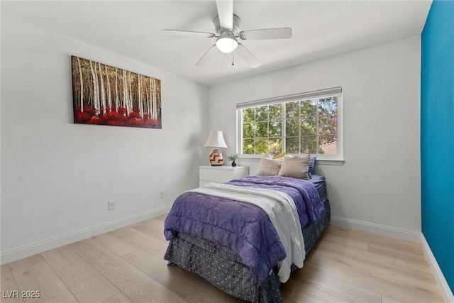 bedroom with a ceiling fan, wood finished floors, and baseboards